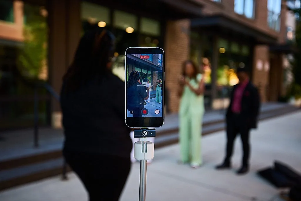 A phone on a tripod films Sheri on the street during a content day